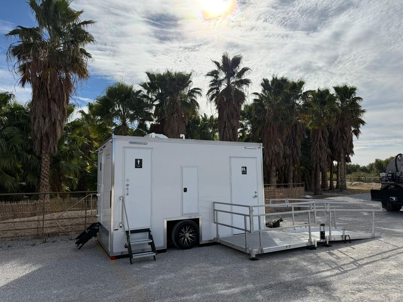 ADA restroom trailer with a wheelchair ramp and railings